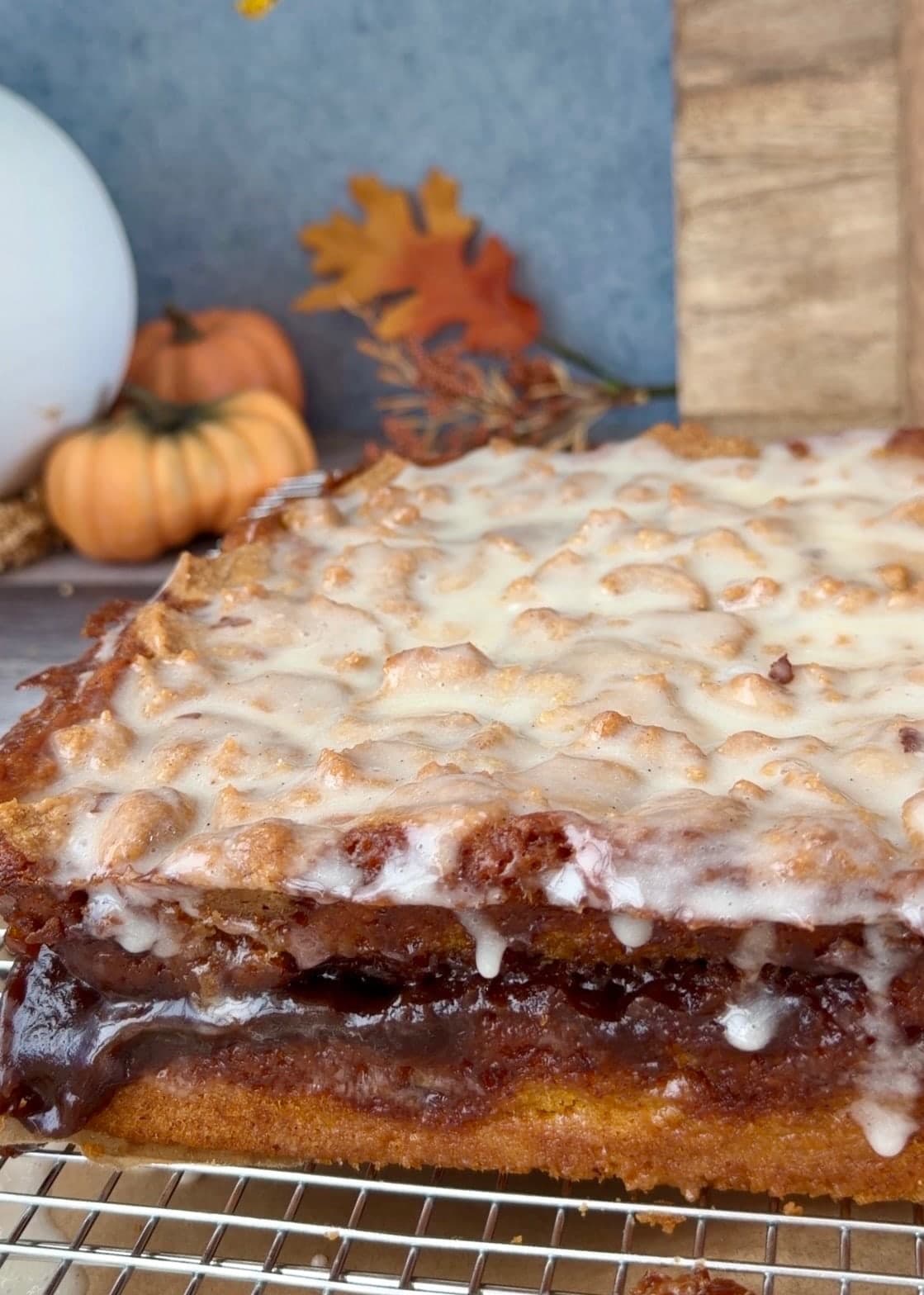 The glazed pumpkin cake resting upright on a wire rack