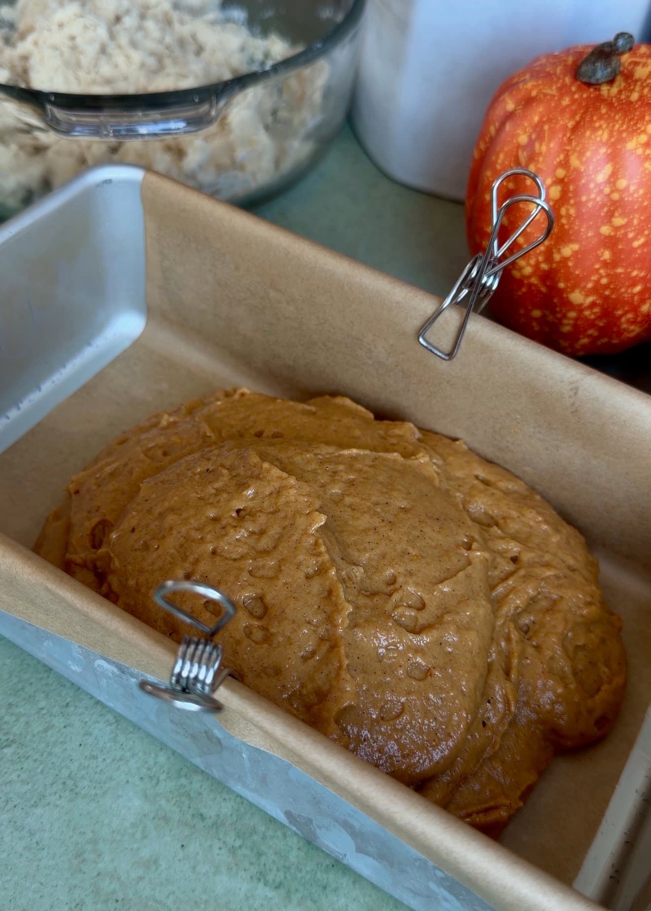 First layer of pumpkin spice batter in a parchment-lined loaf pan