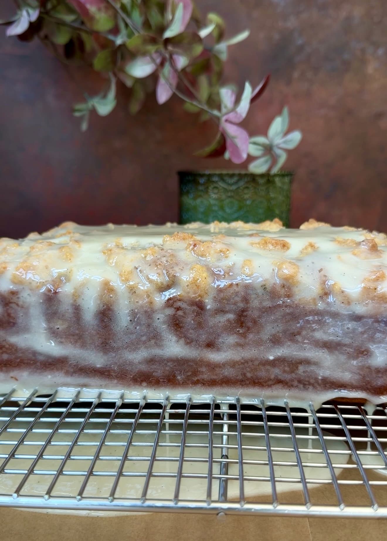 Vanilla crackle glaze settling over the side of pumpkin spice donut loaf