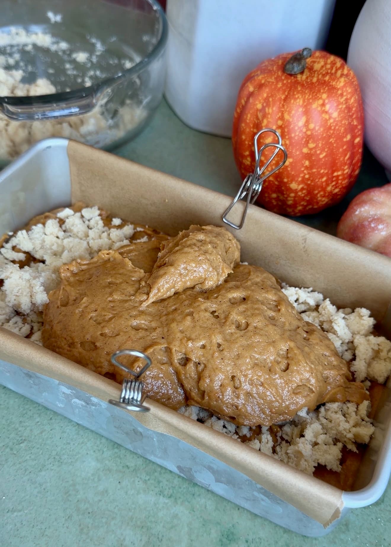 Second layer of pumpkin spice batter being added over the streusel