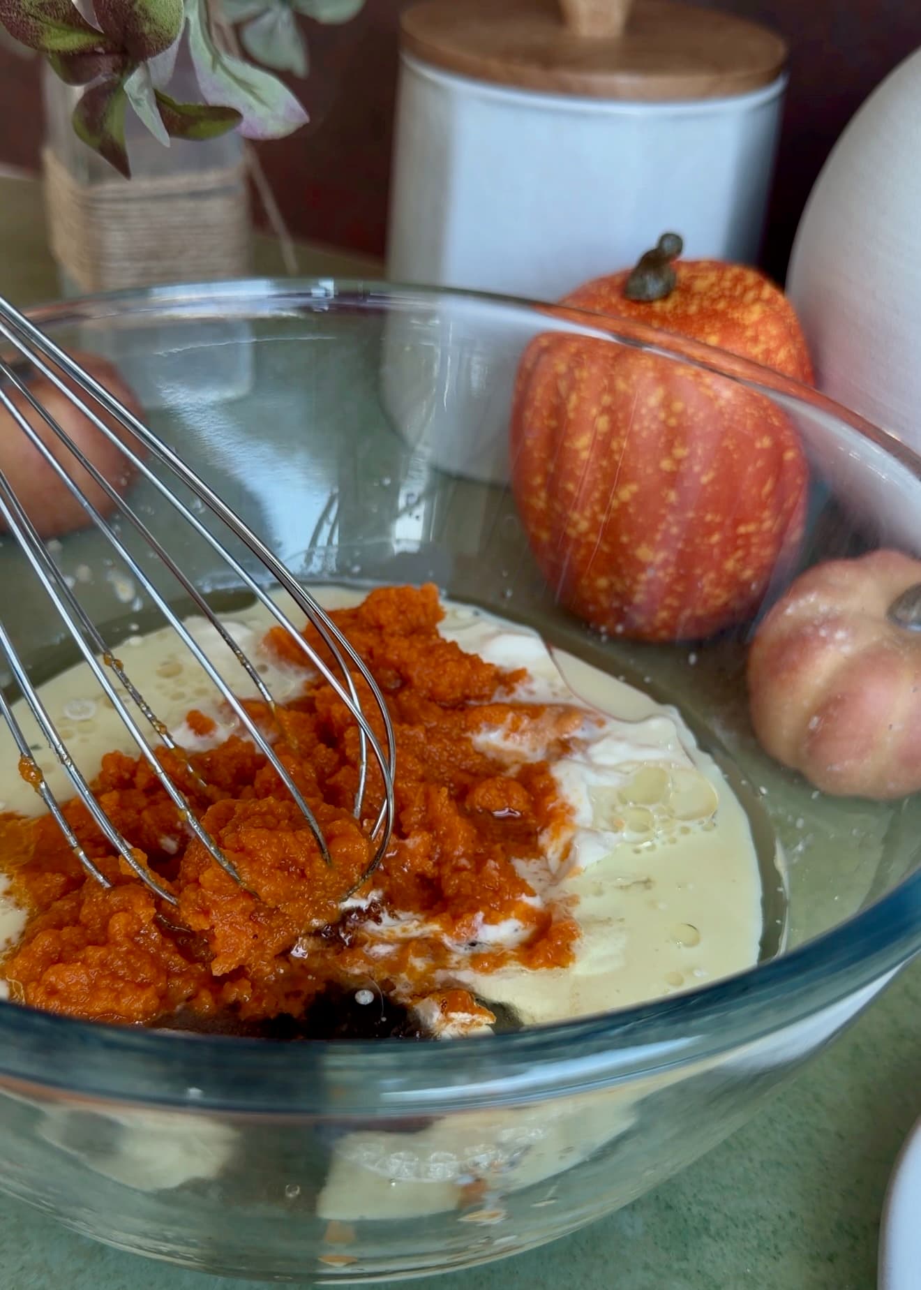 Pumpkin puree, yogurt, milk, oil, and sugar in a glass mixing bowl