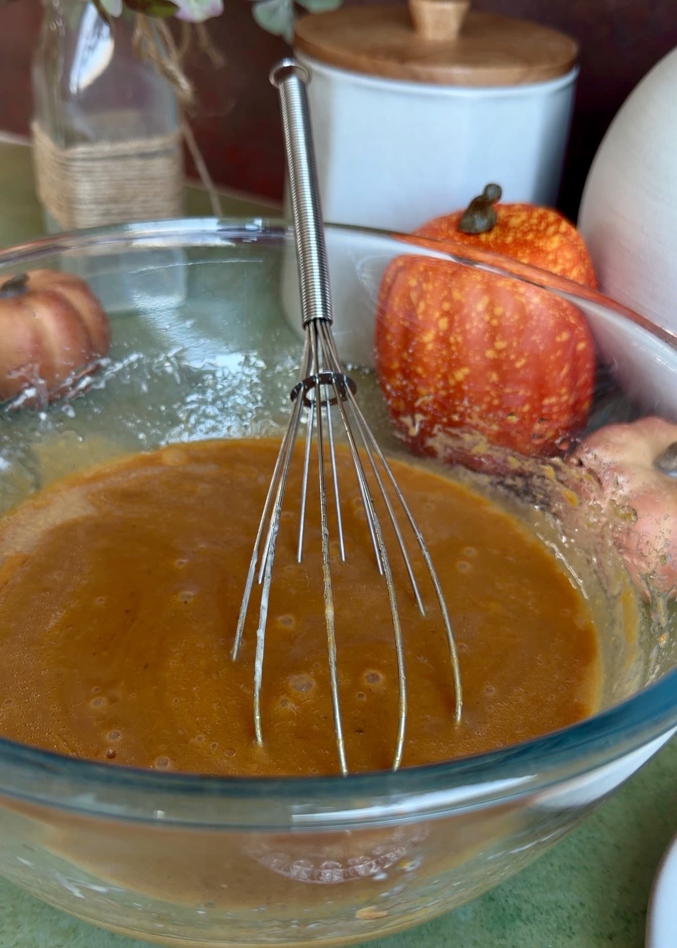Smooth pumpkin spice donut loaf wet mixture in a glass bowl