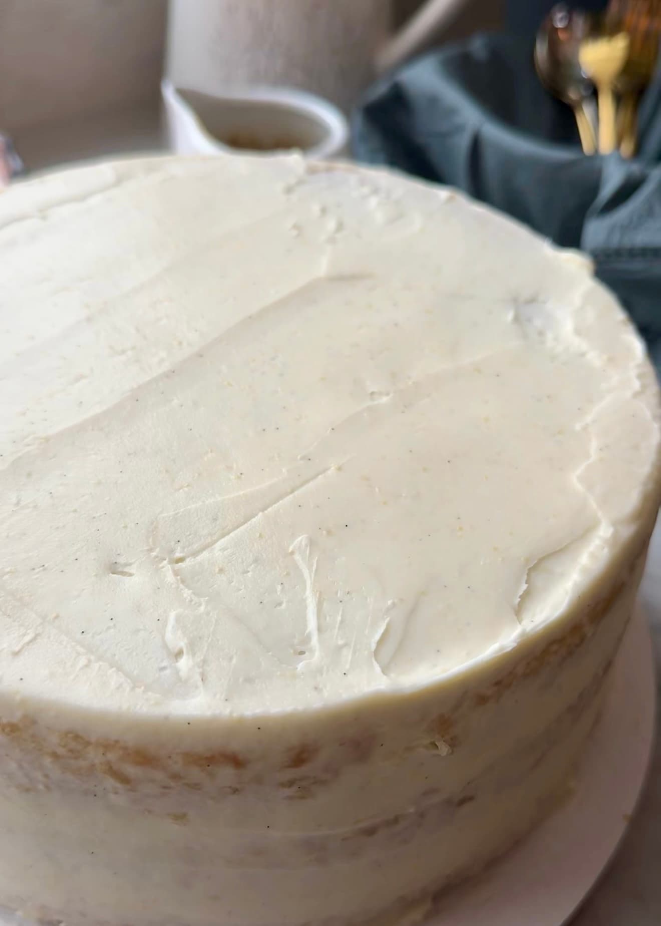 Blondie layer cake covered in a thin cheesecake frosting crumb coat