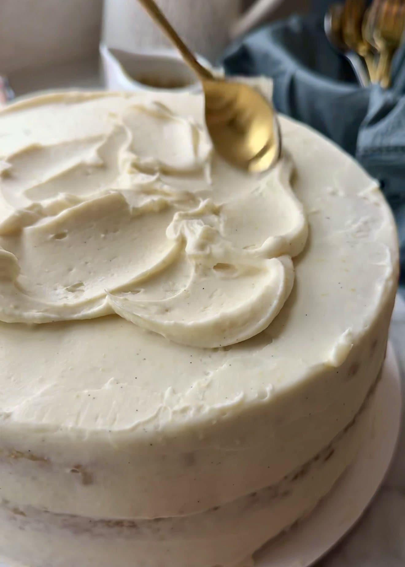 Cheesecake frosting being swirled over the assembled blondie layer cake