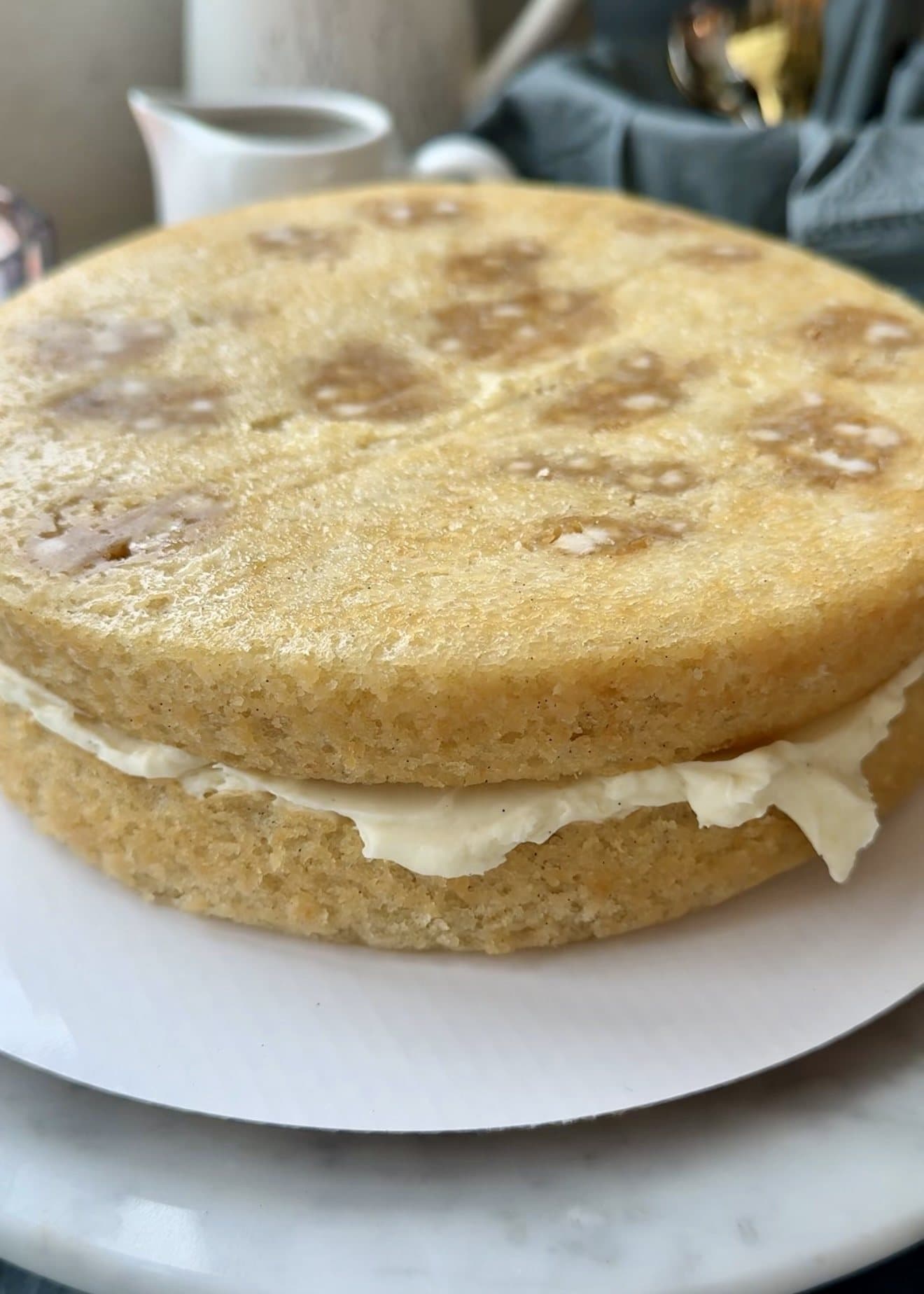 Two blondie cake layers stacked with cheesecake frosting and caramel