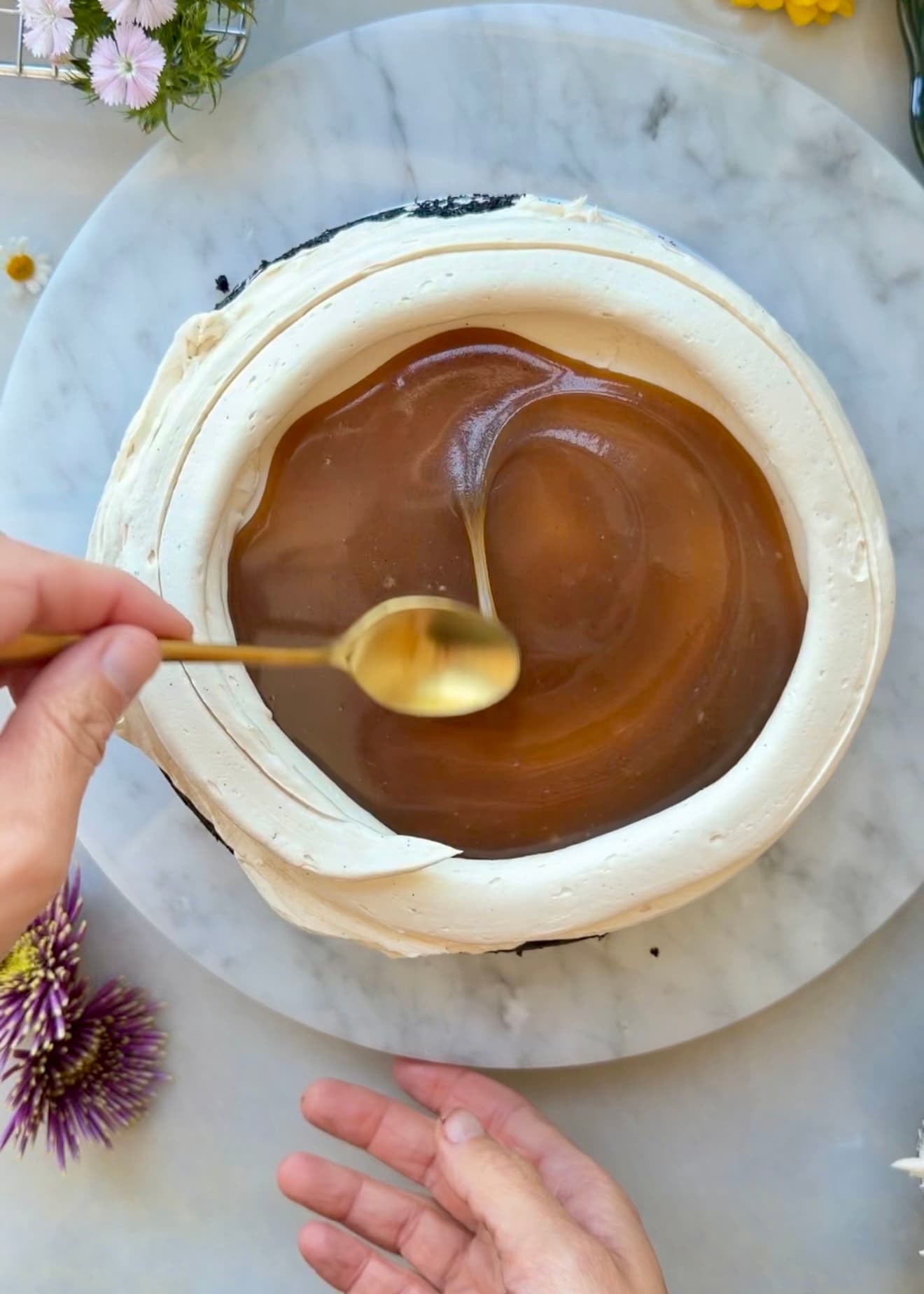 Salted brown sugar caramel spread inside a buttercream dam on mocha cake