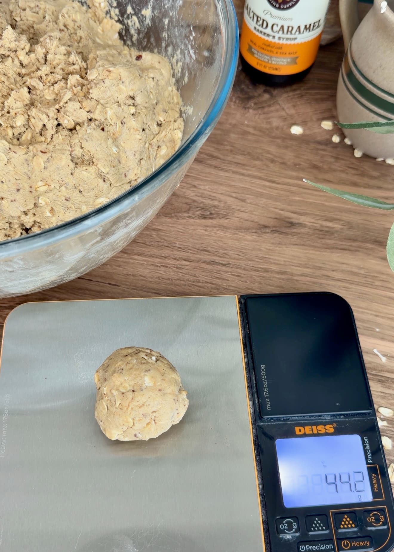 An oatmeal cookie dough portion on a digital kitchen scale