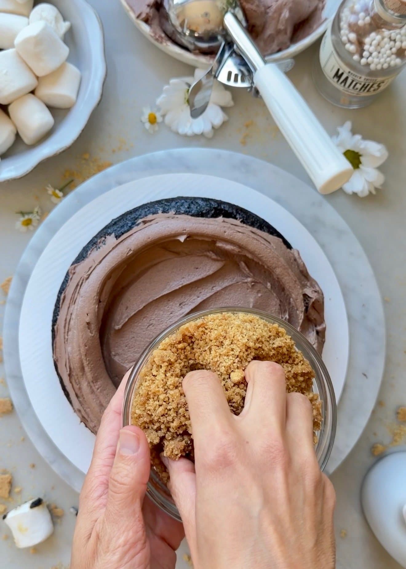 Golden Oreo crunch being scattered over chocolate buttercream inside S’mores Lava Cake