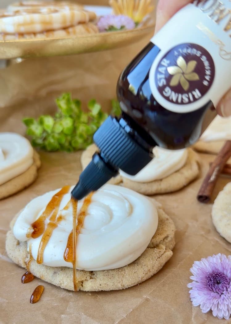 Cinnamon syrup drizzling onto a frosted cookie