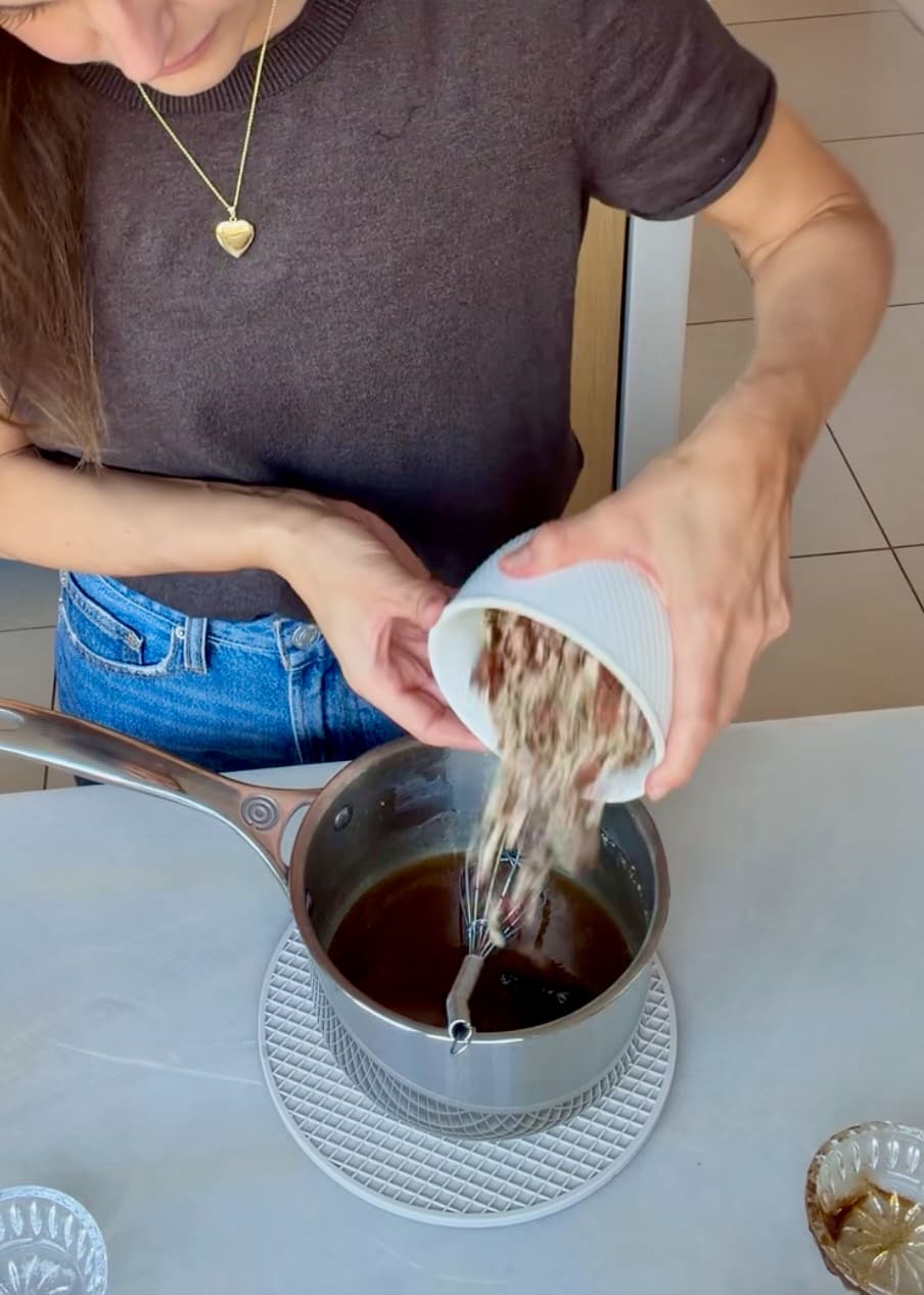 Chopped pecans being poured into the brown sugar topping