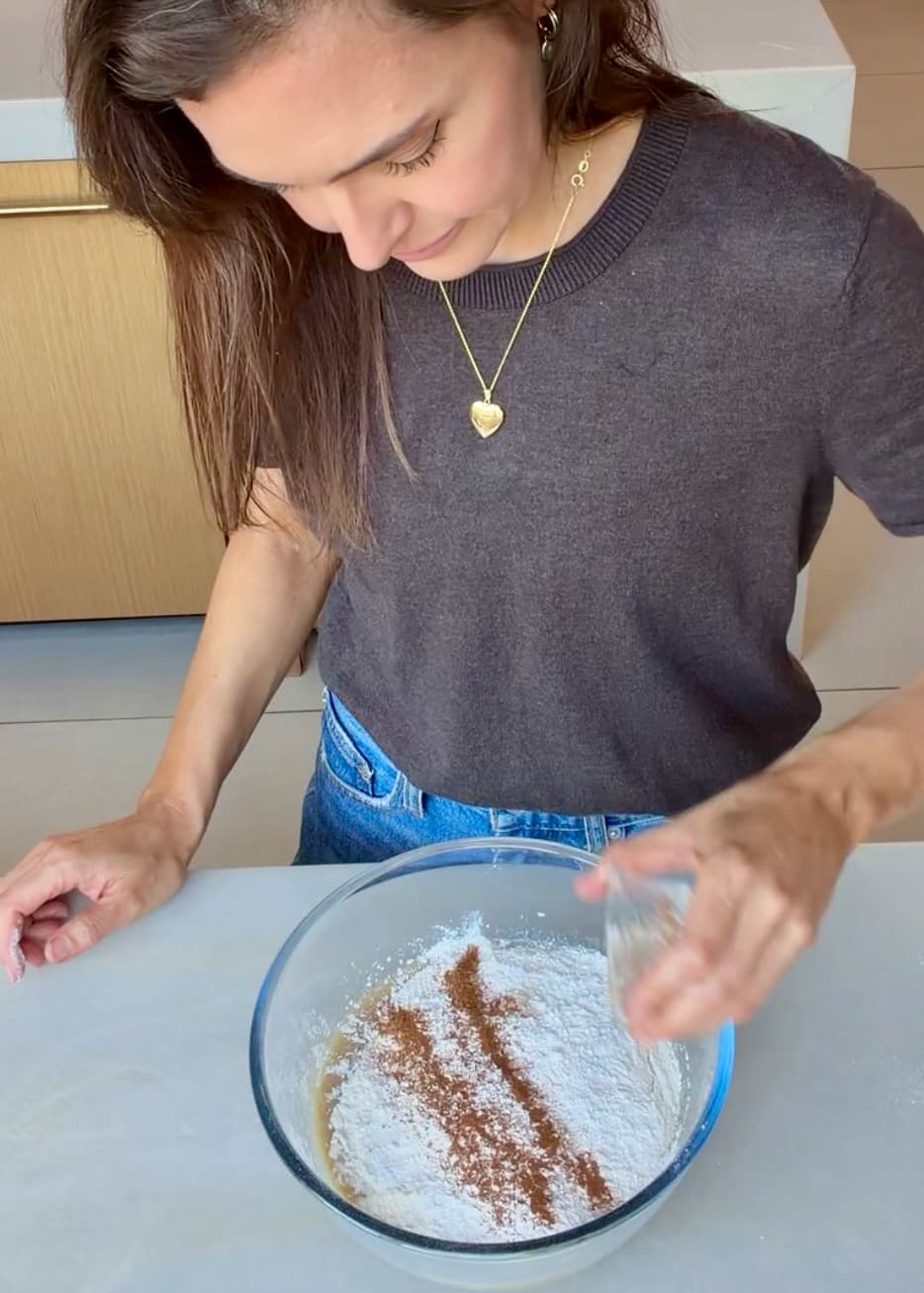 Ground spices being added over flour in the cake mixing bowl