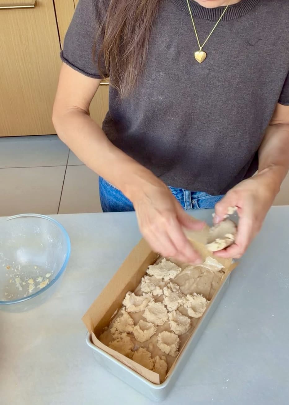 Large crumble clusters covering the first batter layer in a loaf pan