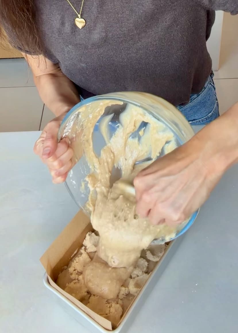 Remaining batter being scraped over the crumble filling