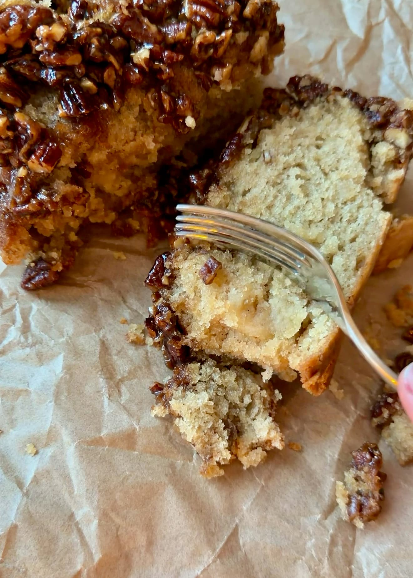 A fork beside a cut slice showing the pale cake and buttery middle