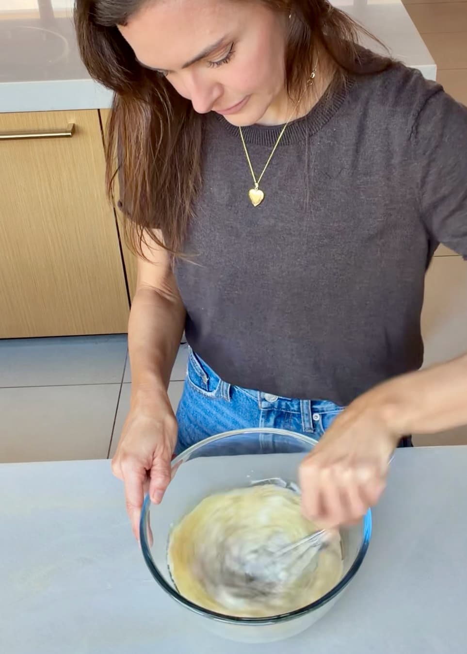 Angela whisking the wet cake ingredients in a glass bowl