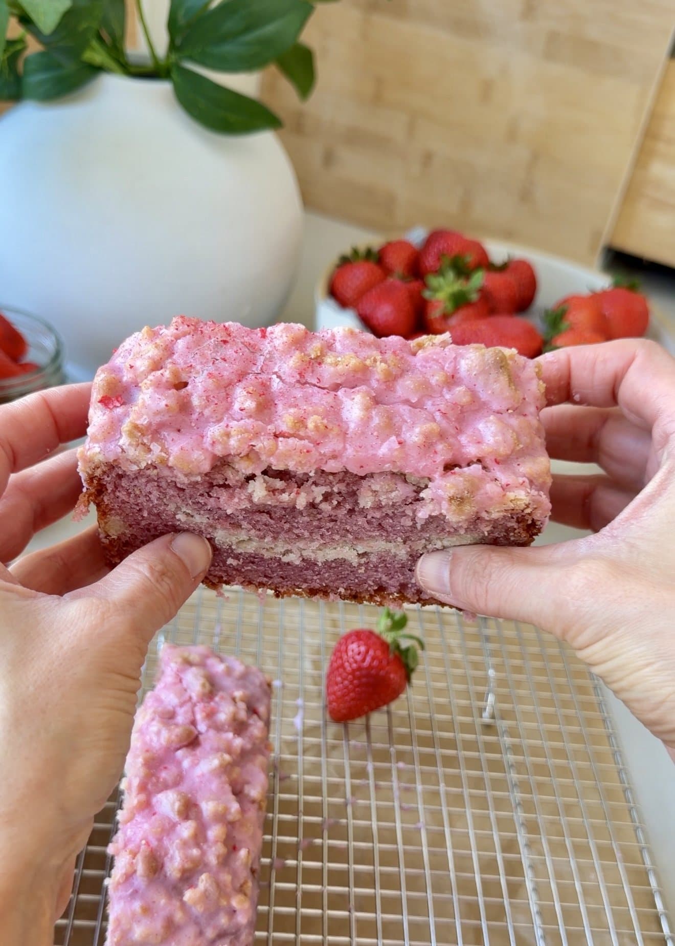 Slice of strawberry old-fashioned donut loaf showing its pink crumb and streusel center
