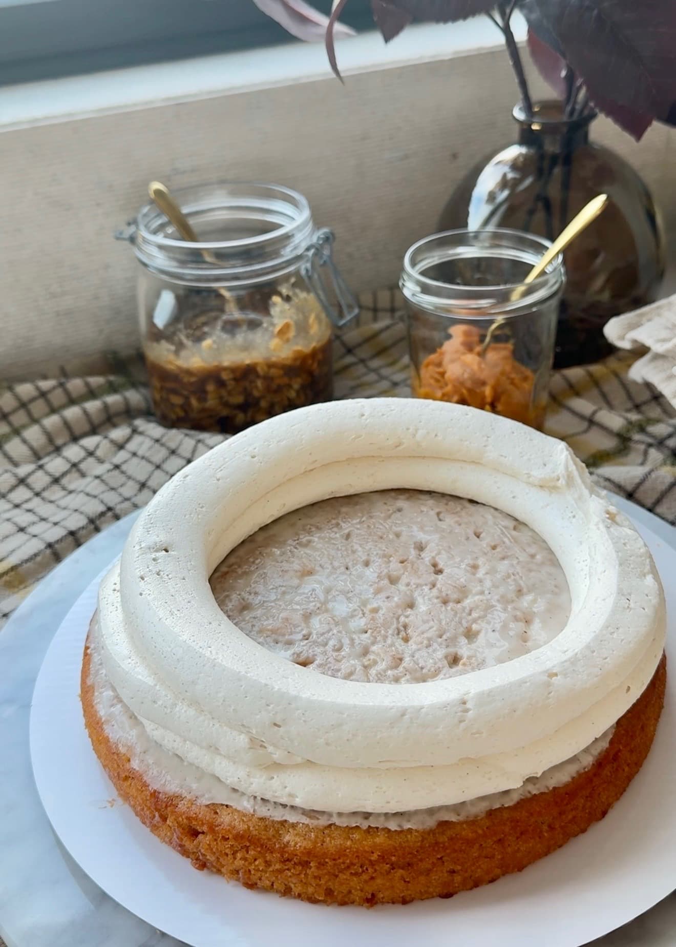 Brown sugar buttercream dam piped around a sweet potato cake layer