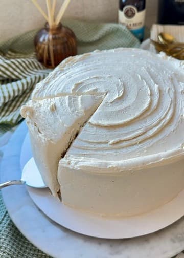 The first slice being cut from a vanilla bean cake with swirled buttercream