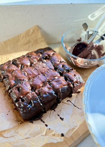 Warm Mocha Poke Cake cut into squares on parchment paper.