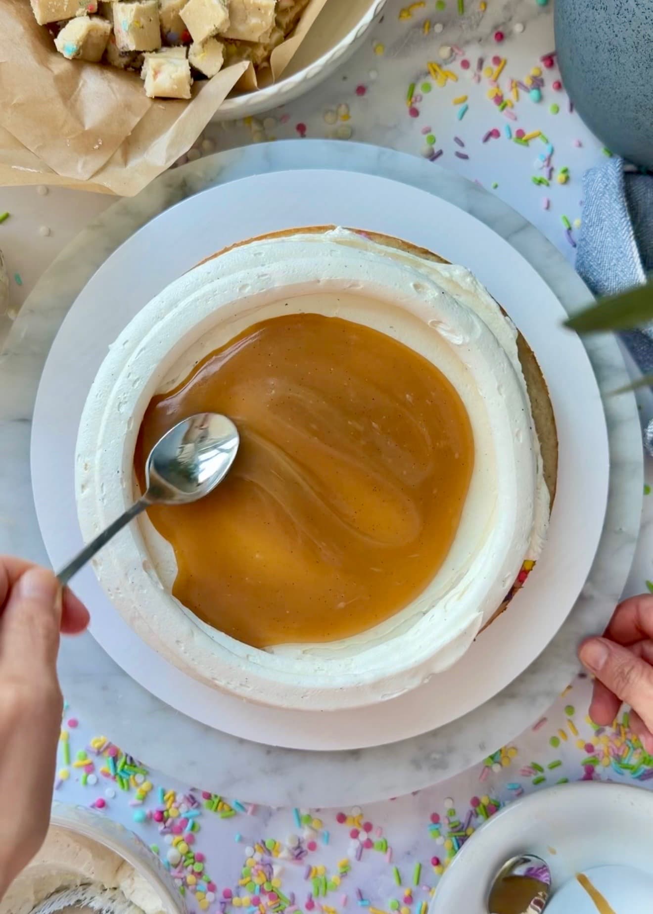 A spoon spreading blondie lava inside the buttercream ring