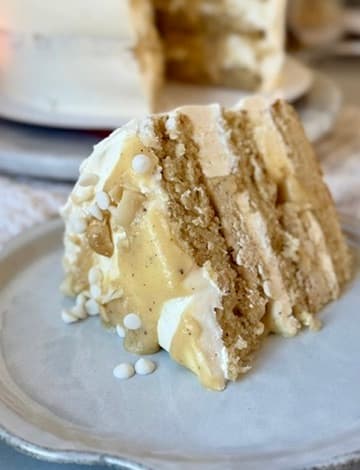 Slice of White Chocolate Macadamia Nut Lava Cake with creamy filling between vanilla cake layers