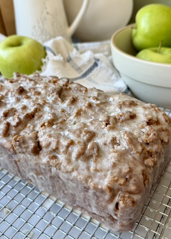 Finished glazed Apple Fritter Old-Fashioned Donut Loaf with green apples in the background