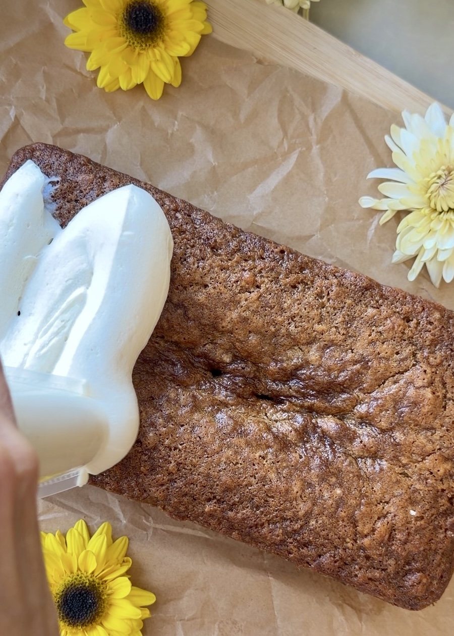Cheesecake mousse being spread over a caramelized banana bread loaf