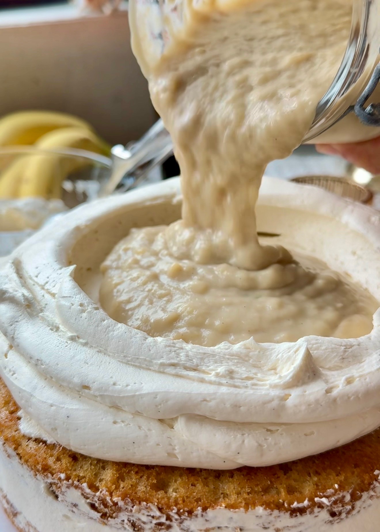 Banana cream pouring inside a vanilla buttercream dam