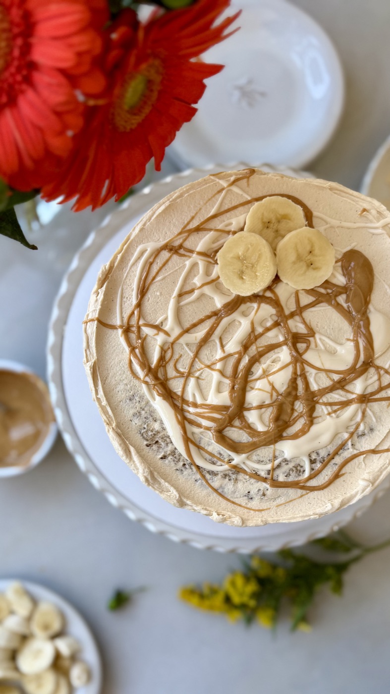 Overhead view of banana fluffernutter cake finished with peanut butter and marshmallow drizzles