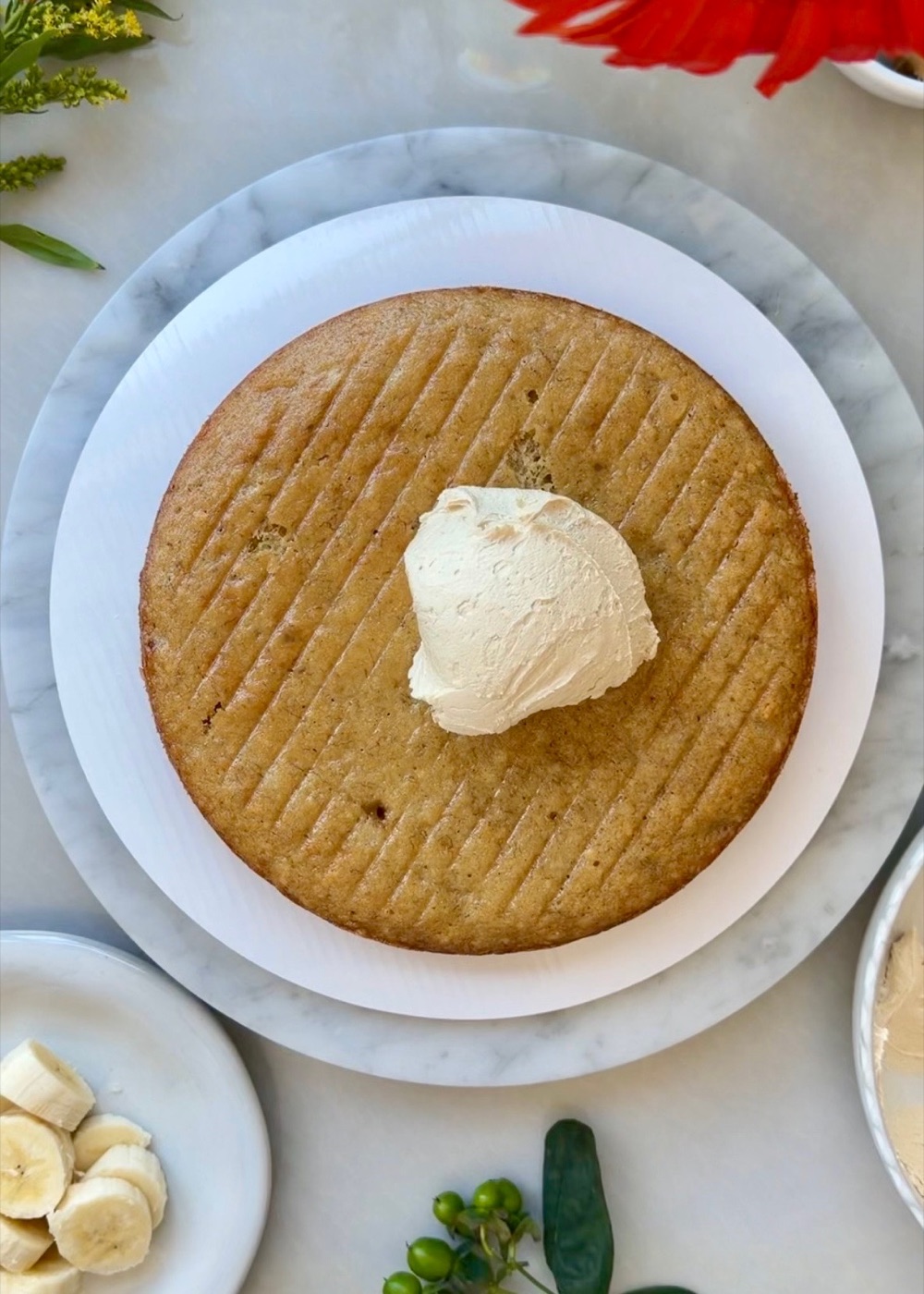Peanut butter buttercream being spread over the first banana cake layer