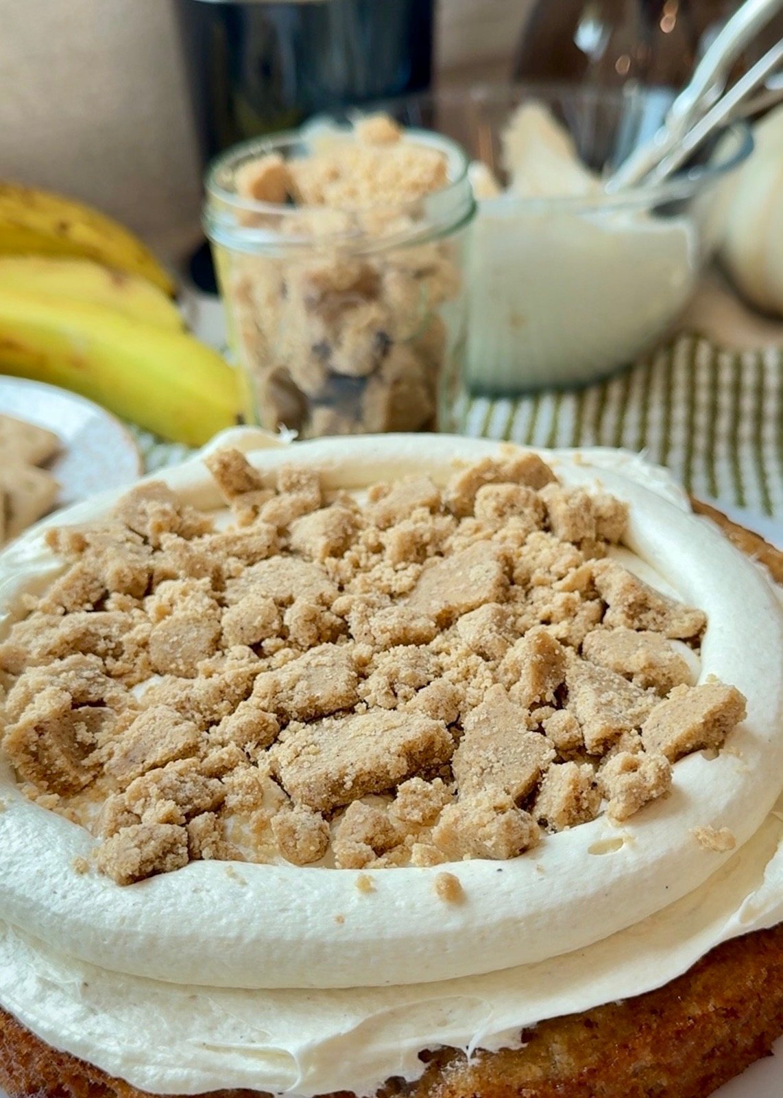 Graham cracker cookie dough layered over cheesecake frosting and banana cake