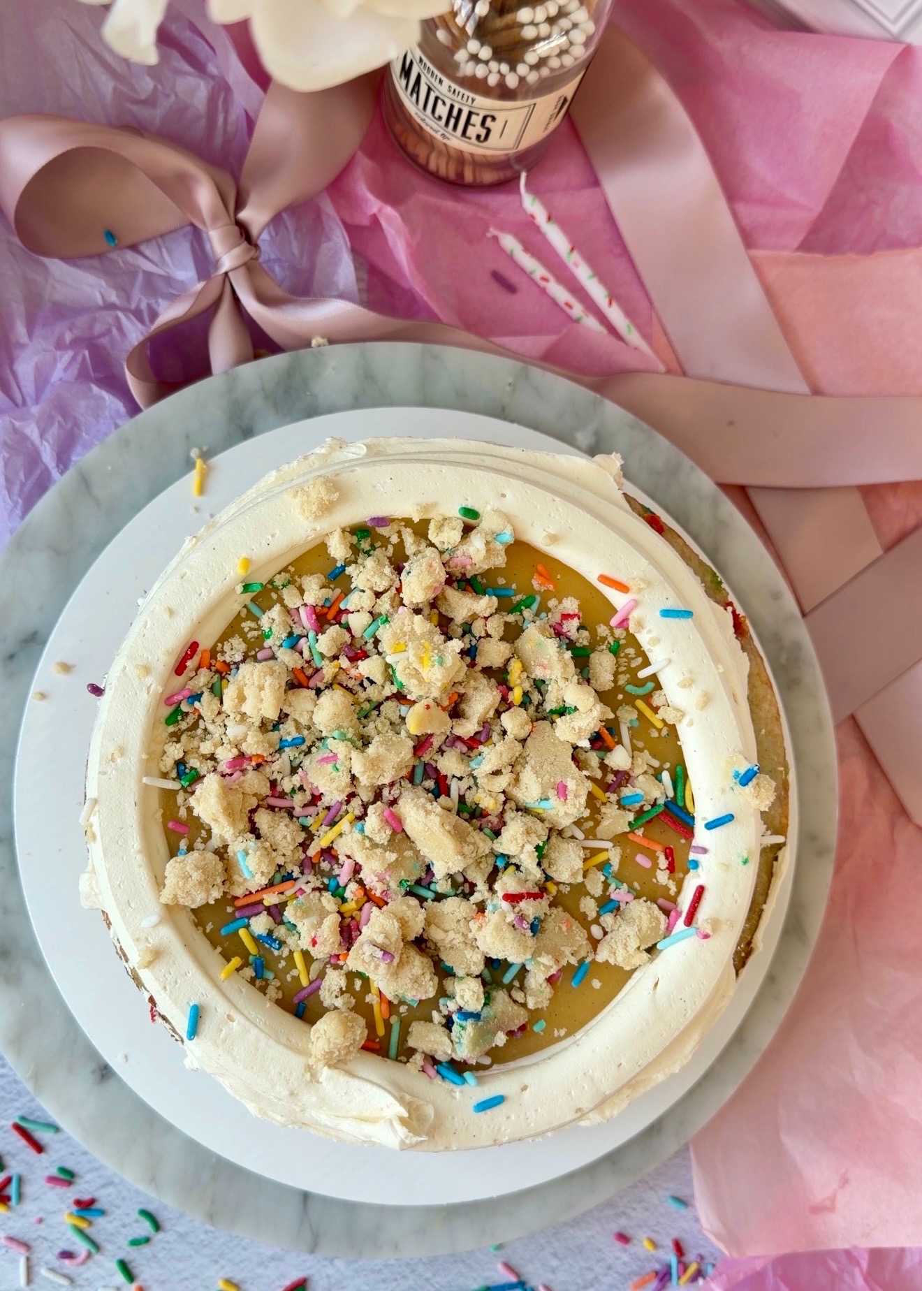 Cake batter lava and sprinkle cookie dough pieces inside a buttercream dam