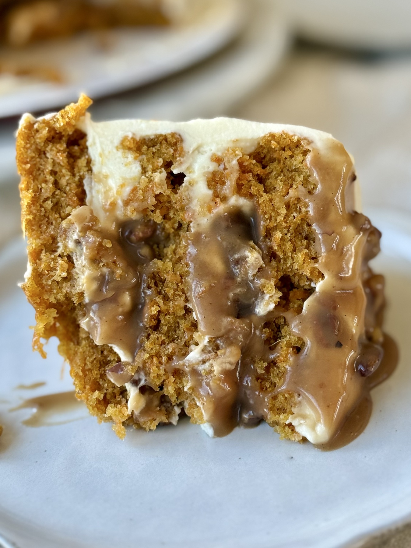 Plated slice of Carrot Praline Cheesecake Cake with pecan caramel filling