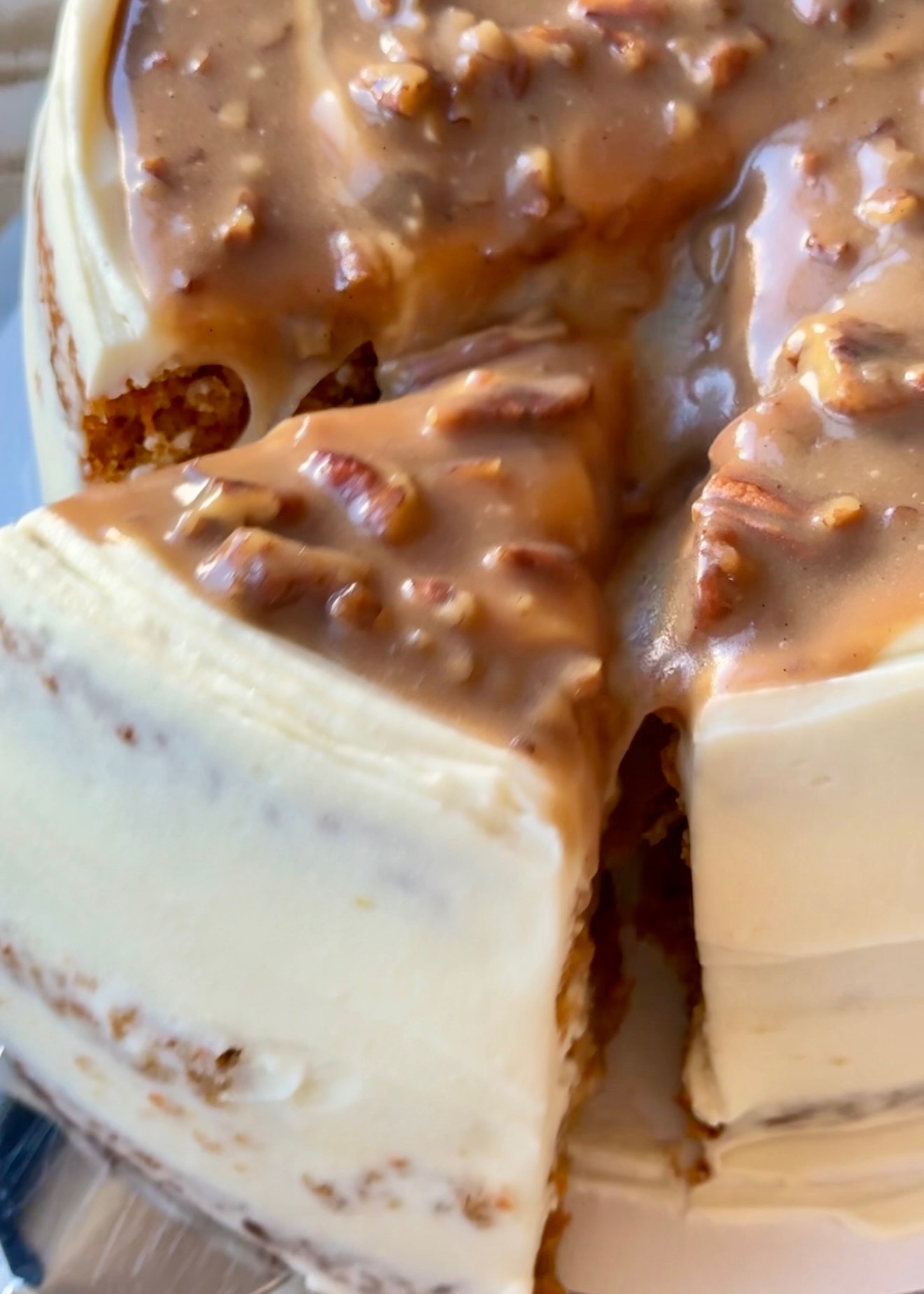 Close view of pecan praline flowing from a cut carrot cheesecake cake