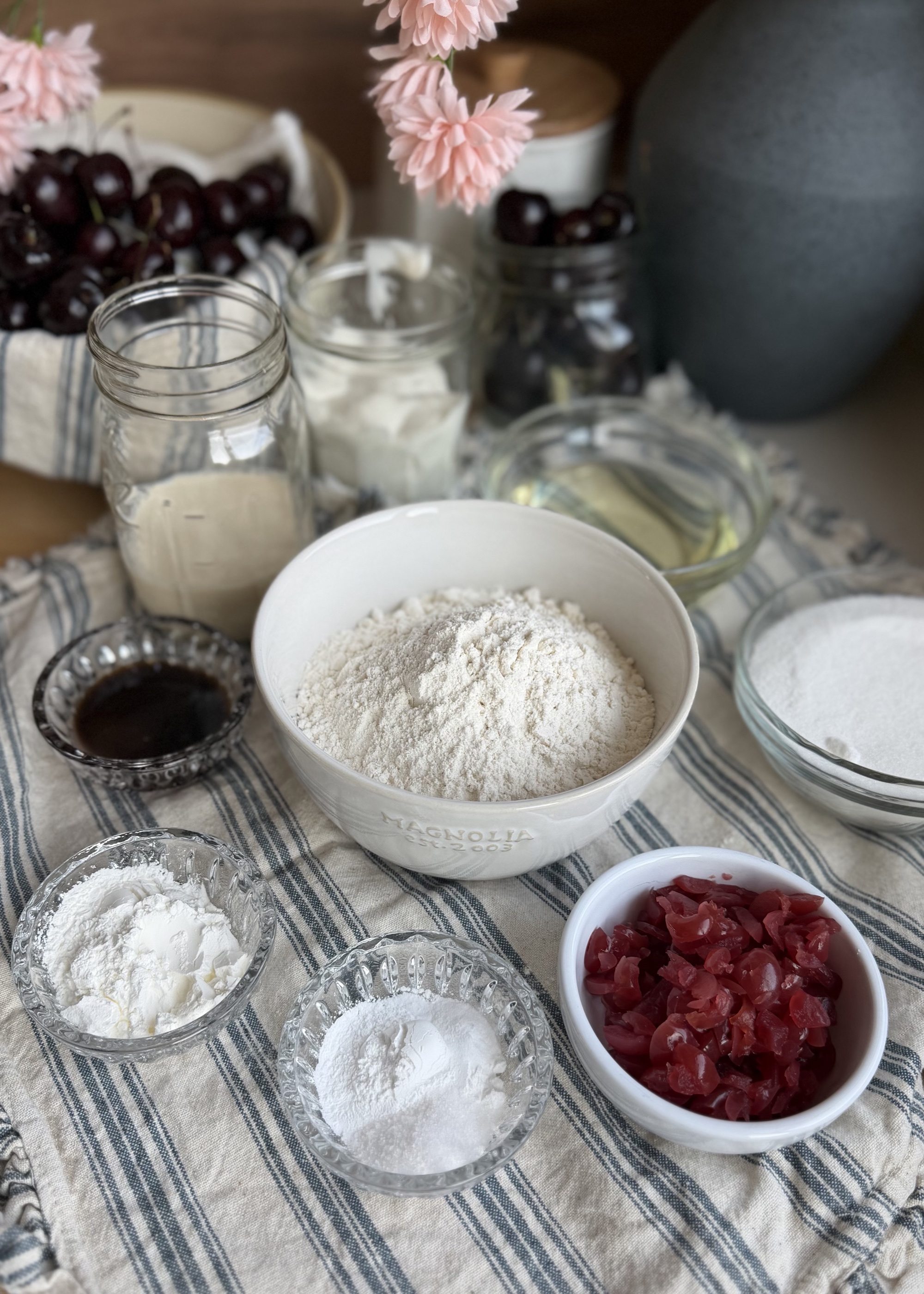 Cherry donut loaf ingredients arranged with chopped maraschino cherries, flour, sugar, yogurt, milk, oil, and vanilla bean paste
