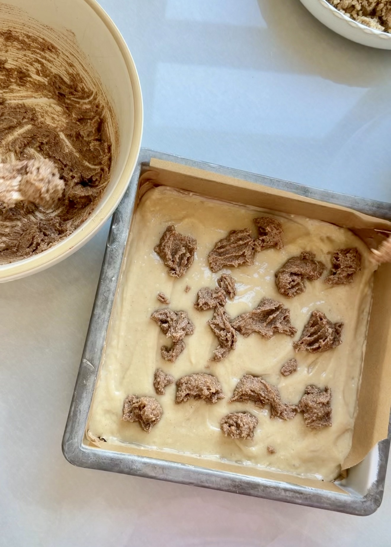 Spoonfuls of cinnamon swirl paste dotted over coffee cake batter
