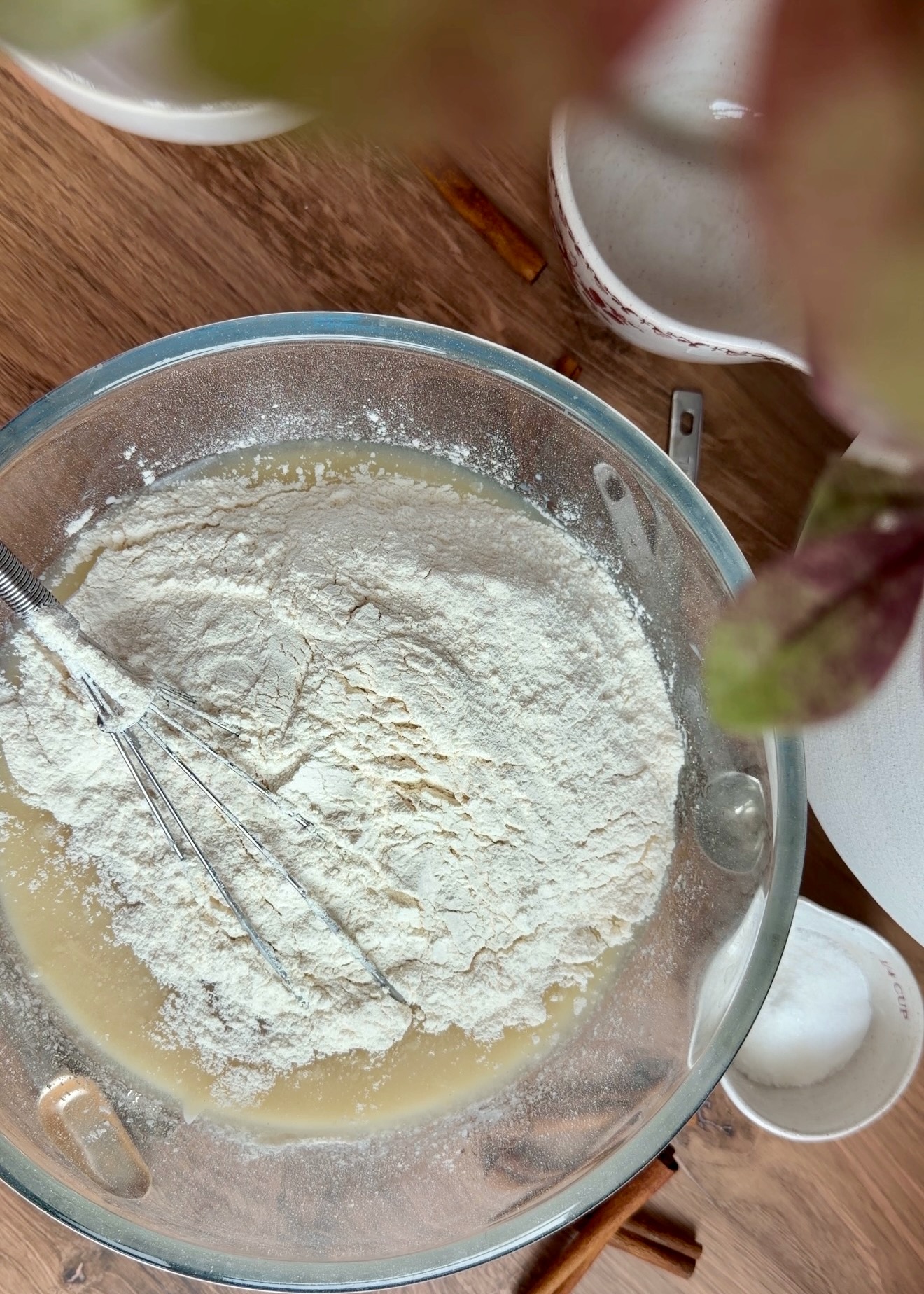 Dry ingredients being added to the wet ingredients for cinnamon-spiced vanilla cake layers