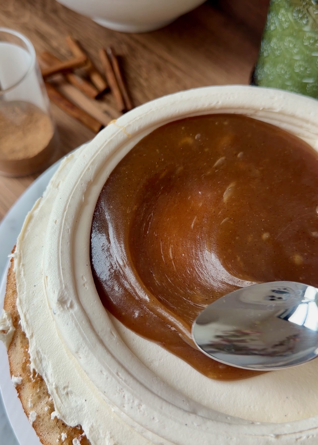 Thick cinnamon filling being spread inside the frosting dam