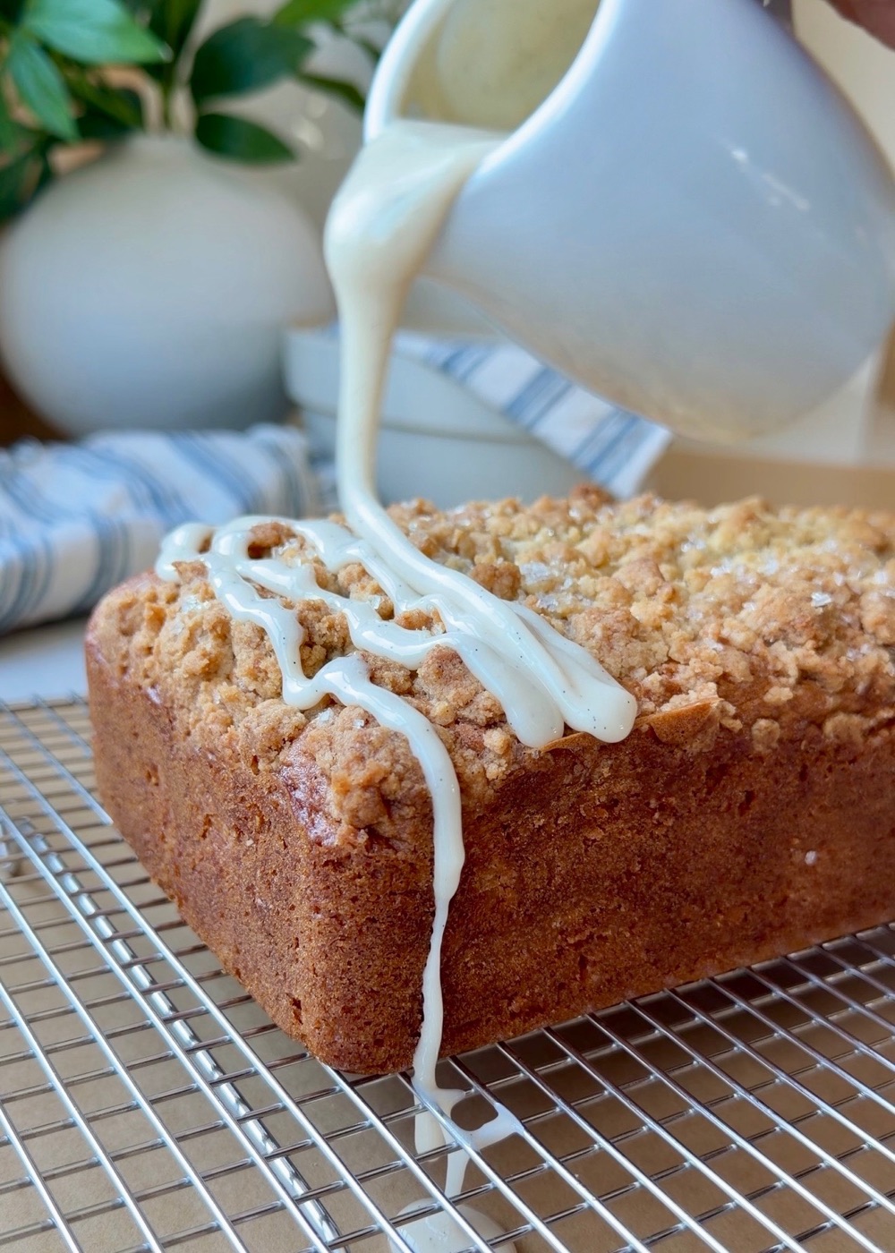 Vanilla-maple crackle glaze being poured over a baked French toast donut loaf
