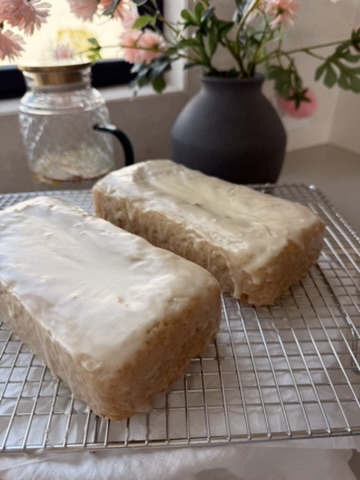 Two glazed gluten-free old-fashioned donut loaves cooling on a wire rack