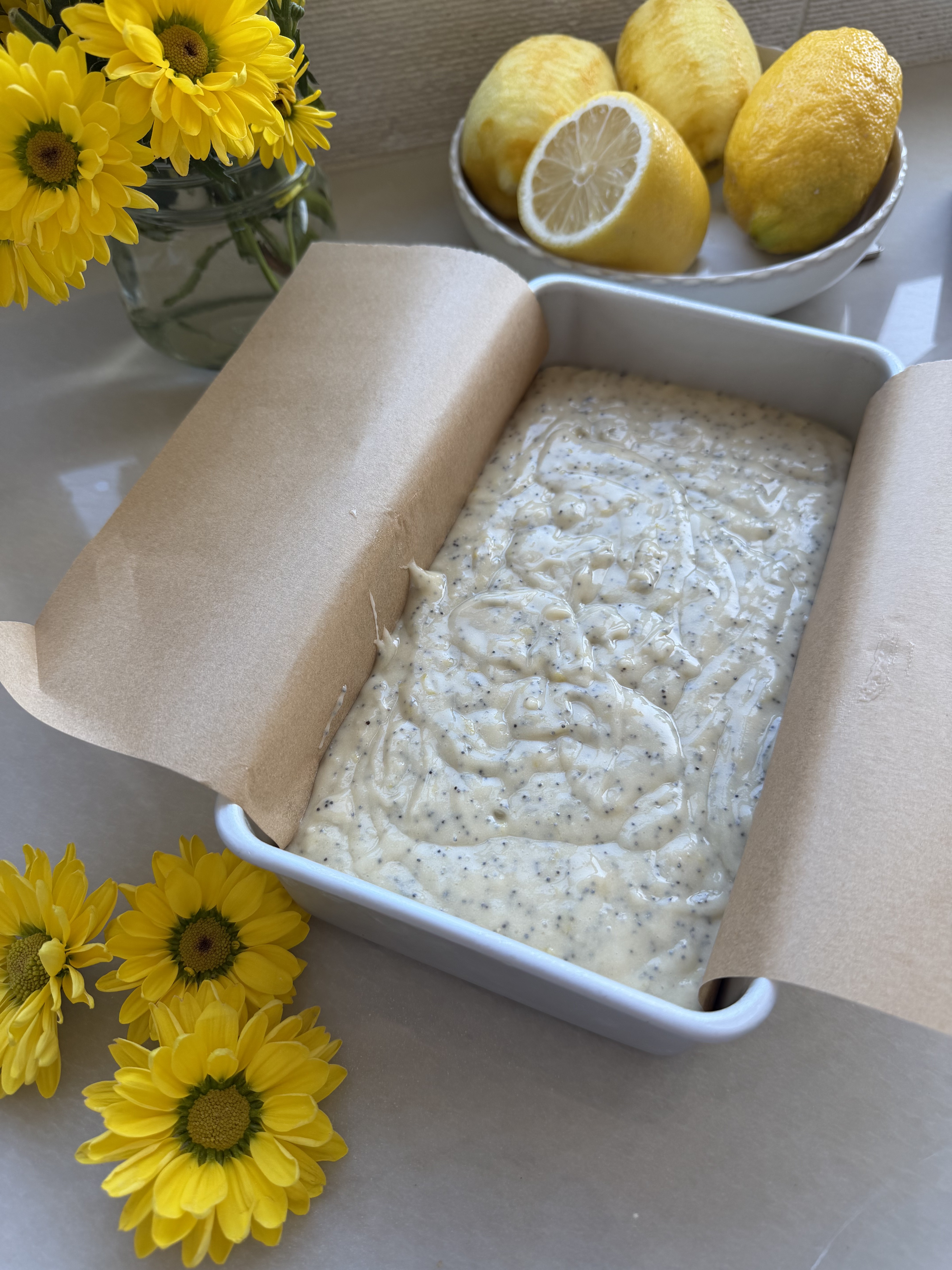Lemon poppy seed batter in a parchment-lined loaf pan