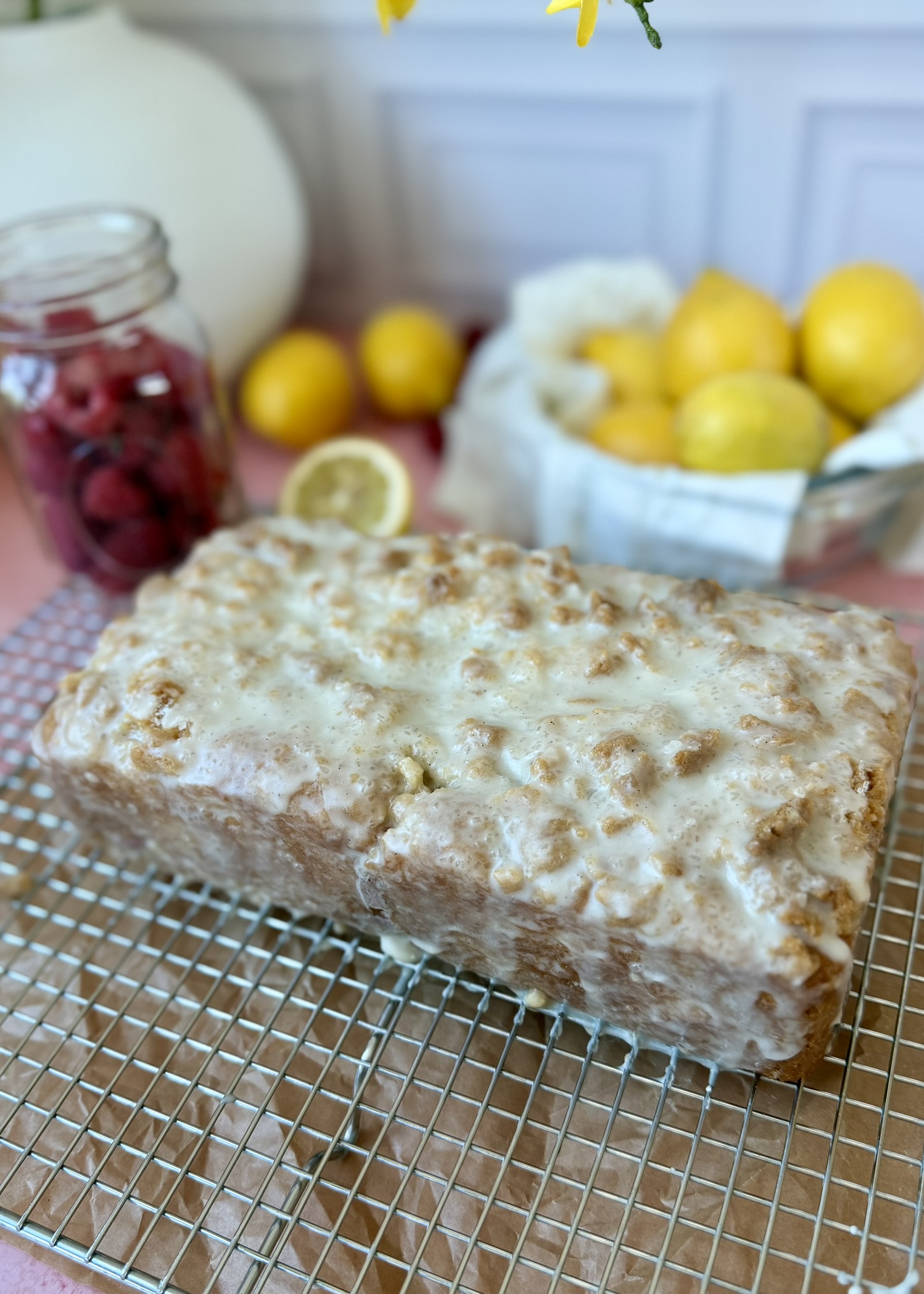 Whole glazed Lemon Raspberry Old-Fashioned Donut Loaf on a cooling rack