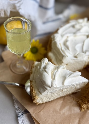 Slice of Limoncello Cheesecake Mousse beside a small glass of limoncello