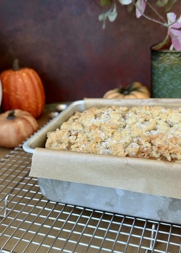 Freshly baked pumpkin spice donut loaf in an aluminum loaf pan