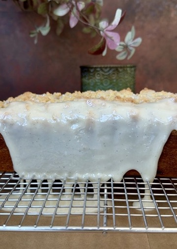 Thick vanilla crackle glaze coating the side of a pumpkin spice donut loaf