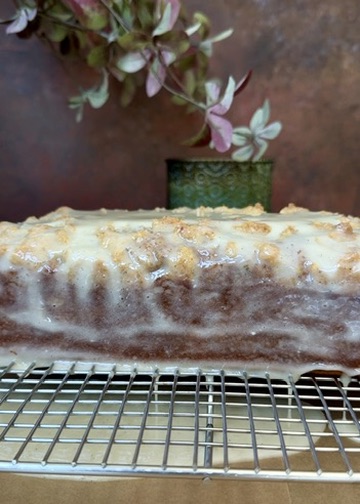 Vanilla crackle glaze settling over the side of the pumpkin spice donut loaf