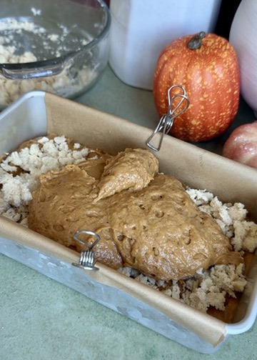 Second layer of pumpkin spice batter being added over the streusel