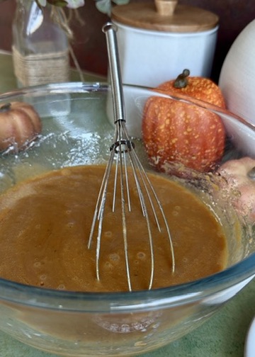 Smooth pumpkin spice donut loaf wet mixture in a glass bowl