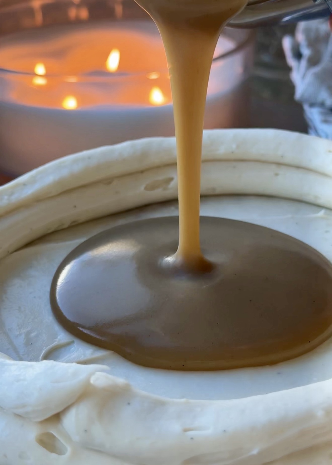 Glossy brown sugar caramel lava pouring into cheesecake frosting