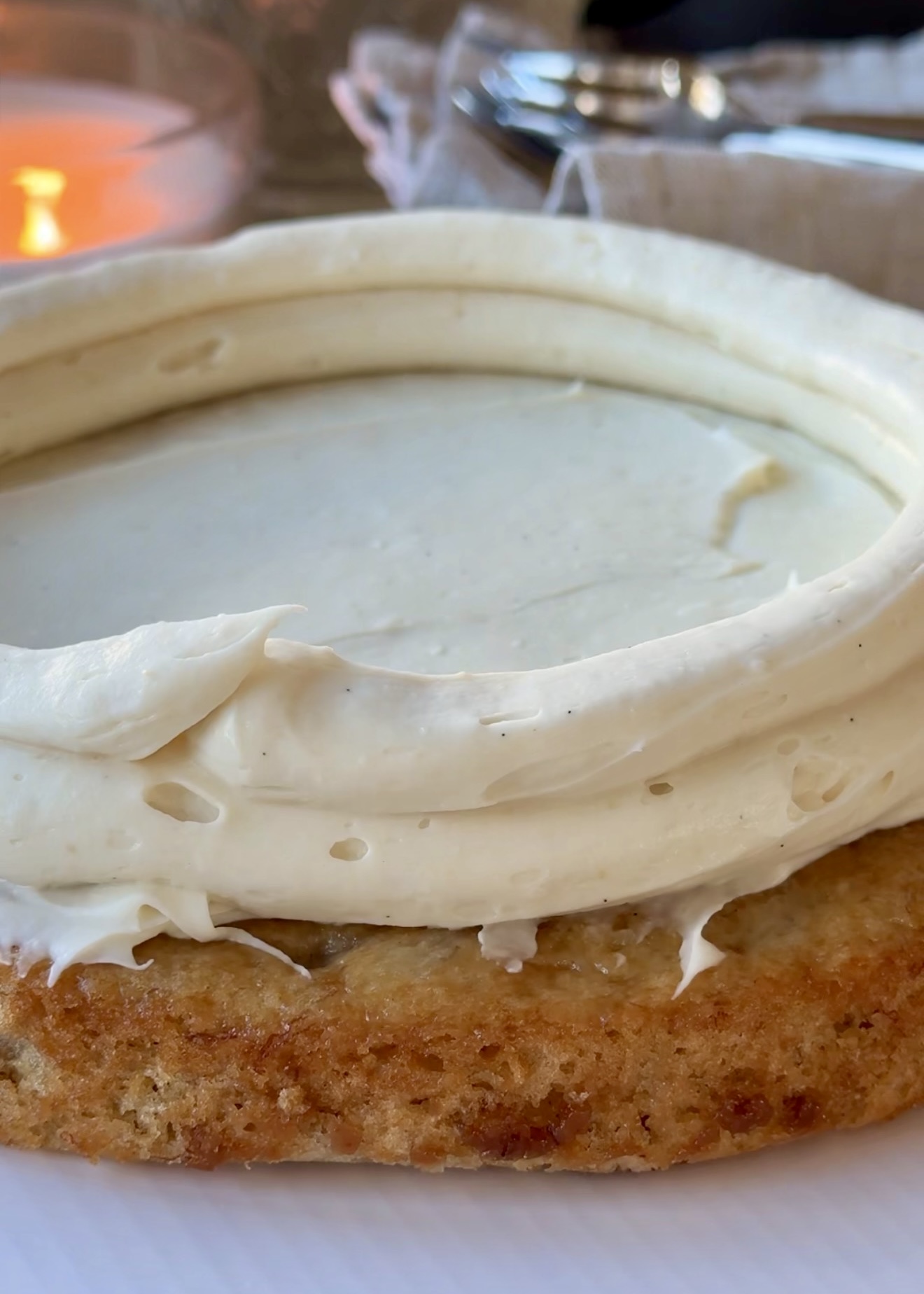 Cheesecake frosting dam piped around a banana cake layer